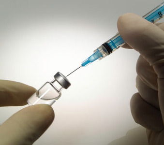 siringa e confezione di vaccino